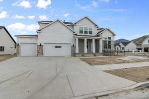 View of front of house with a mountain view, a garage, and covered porch