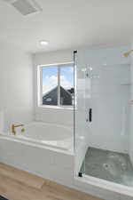 Bathroom featuring shower with separate bathtub