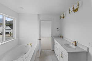 Bathroom with vanity, a bathing tub, and tile patterned floors