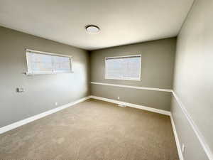 Empty room with carpet floors and a healthy amount of sunlight