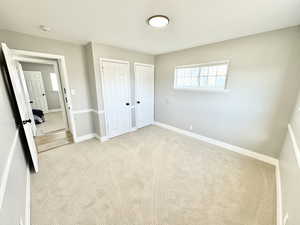 Unfurnished bedroom with light carpet and two closets