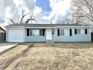 Single story home featuring a garage and a front lawn