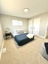 Bedroom with multiple closets and carpet floors