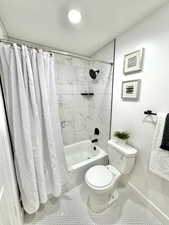 Bathroom featuring shower / tub combo and toilet