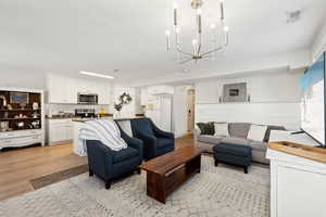 Living room featuring a chandelier and light hardwood / wood-style flooring