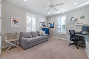 Carpeted office featuring ceiling fan