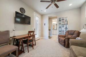 Living room with light colored carpet and ceiling fan