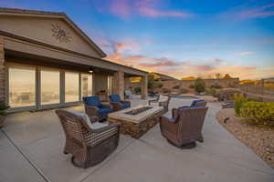 Patio terrace at dusk featuring ceiling fan and a fire pit