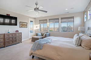 Carpeted bedroom featuring ceiling fan