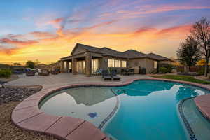 Pool at dusk featuring a patio area