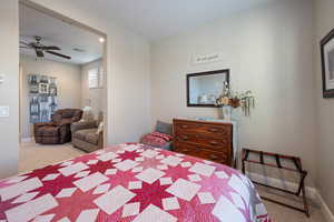 Carpeted bedroom featuring ceiling fan