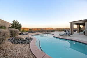 Pool at dusk with a patio area