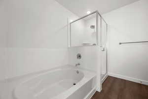 Bathroom featuring hardwood / wood-style floors and shower with separate bathtub