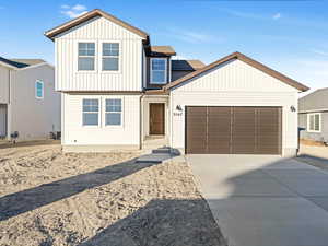 View of front of home featuring a garage and central AC unit