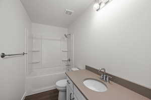 Full bathroom with vanity, hardwood / wood-style floors, toilet, and shower / bath combination