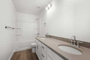 Full bathroom featuring shower / bathtub combination, vanity, toilet, and hardwood / wood-style floors