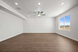 Unfurnished room featuring ceiling fan, a mountain view, dark wood-type flooring, and a textured ceiling