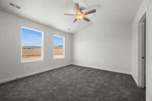 Unfurnished bedroom with lofted ceiling, ceiling fan, and dark colored carpet