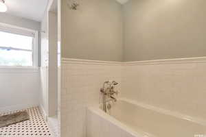 Bathroom featuring a soaking tub, tile patterned floors, tile walls, and separate tile shower