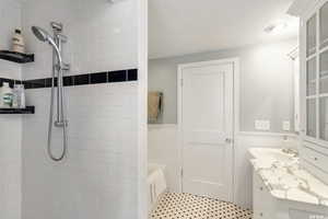 Bathroom featuring walk in shower, separate soaking tub, double vanities and tile patterned flooring