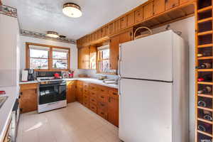 Kitchen with a textured ceiling and white appliances