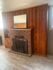 ADU living room details with wood-type flooring, a brick fireplace, and a textured ceiling