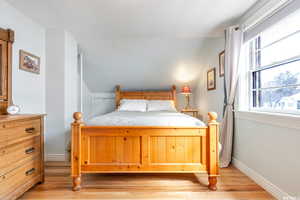 Upstairs Bedroom with vaulted ceiling and light hardwood floors