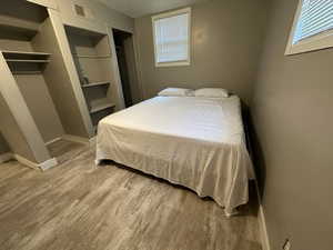 Bedroom with laminate flooring, multiple windows, and a textured ceiling