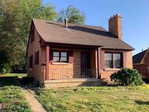 Front of home featuring a covered porch and a front yard