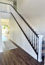 Stairway featuring a towering ceiling and hardwood / wood-style floors