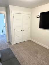 Unfurnished bedroom with carpet floors, a closet, and a textured ceiling