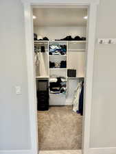 Walk in closet featuring light carpet