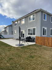 Rear view of property featuring a yard and a patio