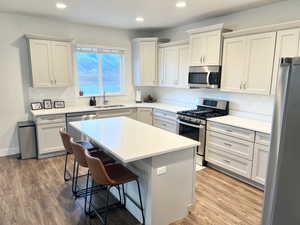 Kitchen featuring stainless steel appliances, sink, a kitchen island, and grey cabinets