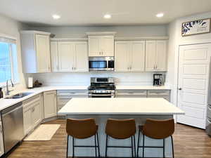 Kitchen featuring stainless steel appliances, a center island, sink, and grey cabinets