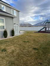 View of yard with a playground, a shed, and a mountain view