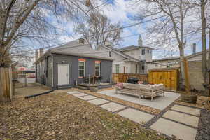 Rear view of house with an outdoor living space, an outbuilding, a patio area, and a wooden deck