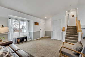 Living room with lofted ceiling and carpet floors