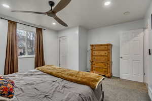 Carpeted bedroom featuring ceiling fan