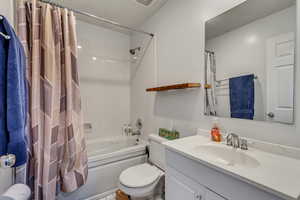 Full bathroom featuring shower / tub combo with curtain, vanity, and toilet