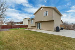 Back of property with central AC, a patio, and a lawn