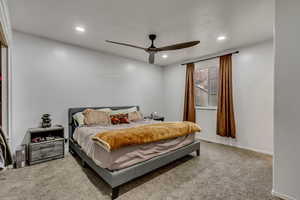 Carpeted bedroom featuring ceiling fan