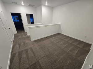 Unfurnished room with dark colored carpet