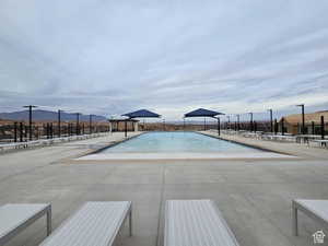 View of pool with a mountain view and a patio