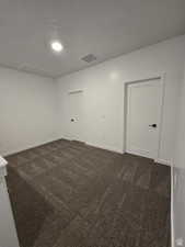 Unfurnished room with dark colored carpet