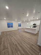 Unfurnished living room featuring sink, hardwood / wood-style flooring, and a textured ceiling