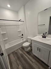 Full bathroom with wood-type flooring, toilet, vanity, and shower / bathing tub combination