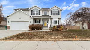 View of front of property featuring a garage and a front lawn