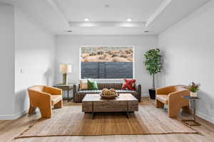 Living area with a tray ceiling and hardwood / wood-style flooring