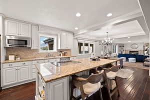 Kitchen featuring white cabinetry, decorative light fixtures, dark hardwood / wood-style flooring, a tile fireplace, and a kitchen island